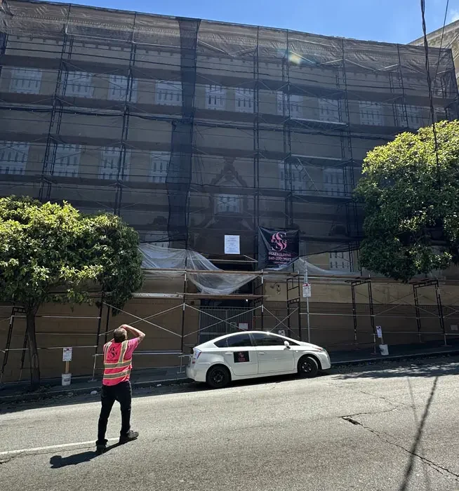 Fremont Scaffolding Rental scaffolding covered with safety netting on multi story building
